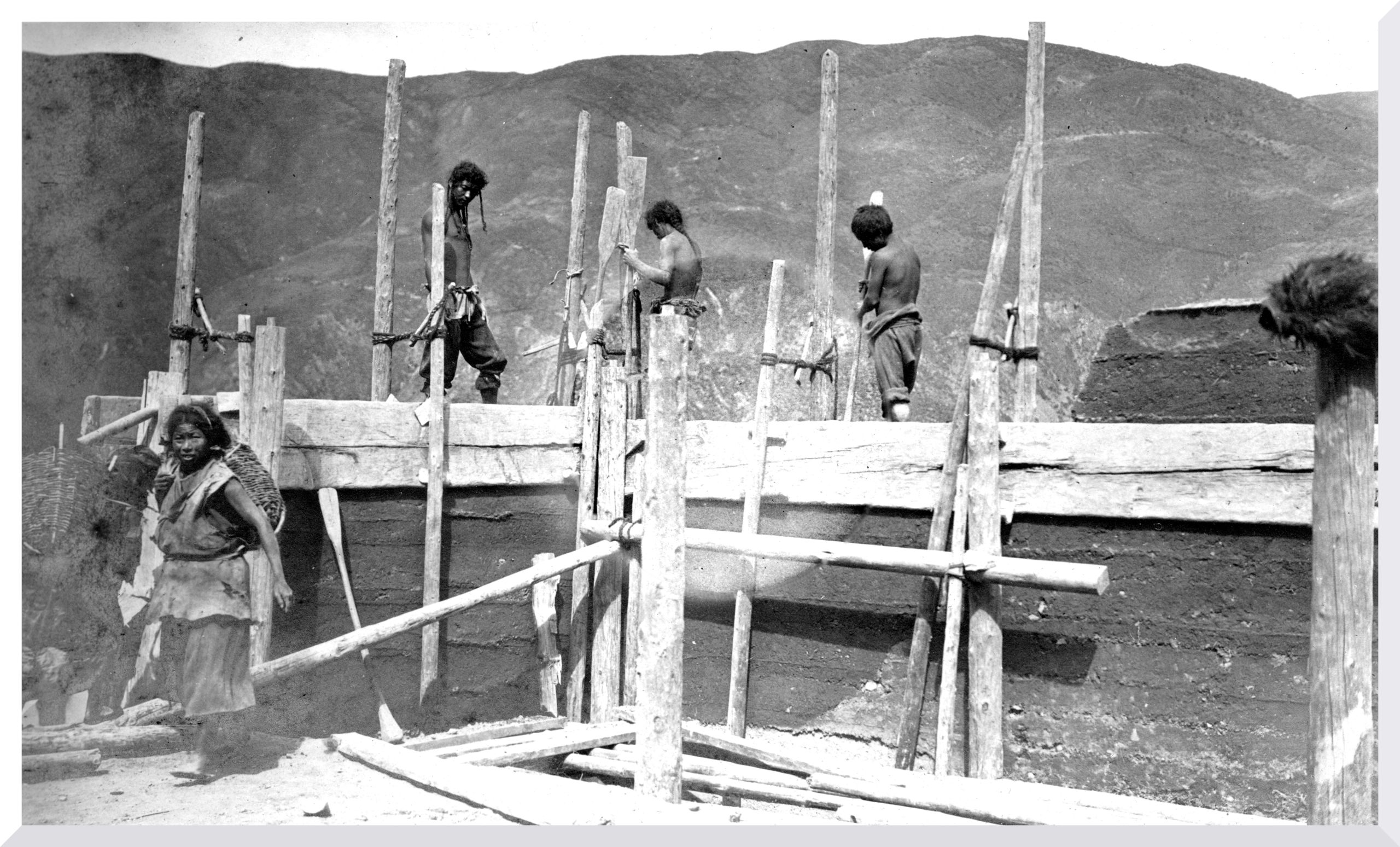 Picture of Tibetans re-building houses putting up wooden frame