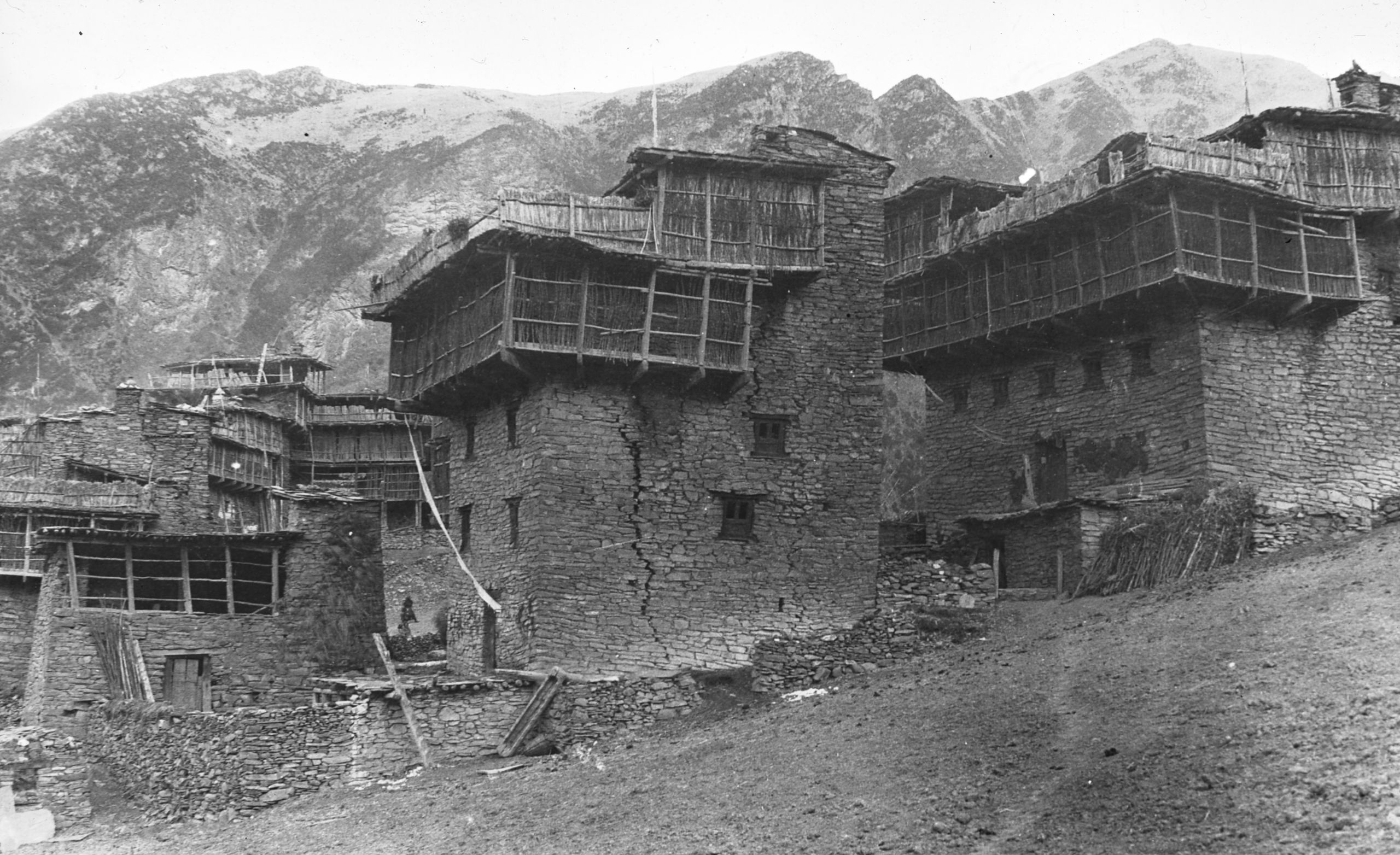 Picture of some Houses - one with a great big crack in K'a-ka-roh valley with mountains in the background